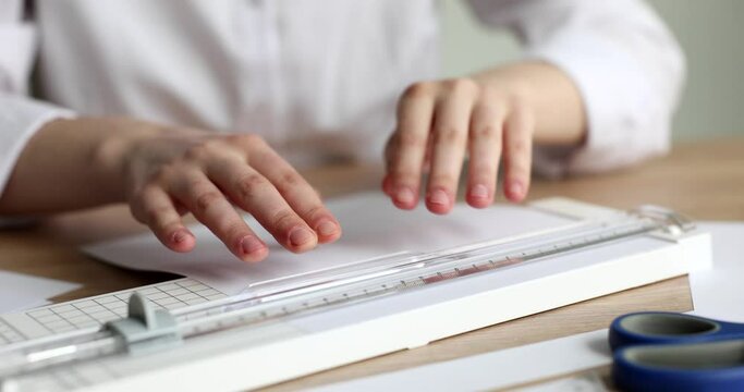 Woman hands cutting drawing with paper knife paper knife with ruler guillotine closeup 4k movie slow motion. Modern stationery concept