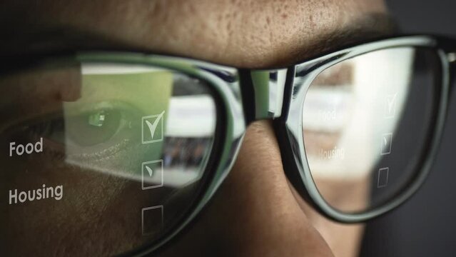 Search the Internet pages and icons with symbols about fulfilling life tasks and priorities in the reflection of glasses on a male face. Cg