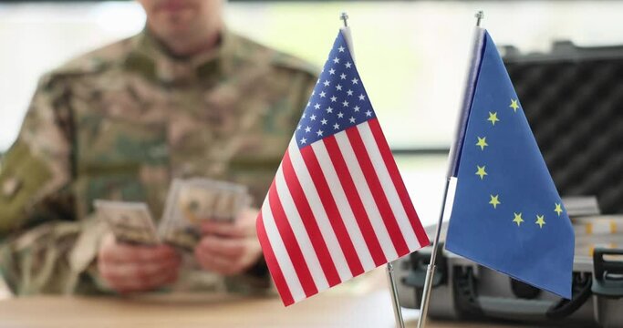 Military man counting money at table with eu and usa flags closeup 4k movie slow motion. Financial benefits of war between Ukraine and Russia for Western countries concept