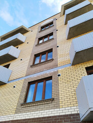 Facade of new multi story residential building. Sale and rental apartments. Housing development. Cityscape. City living. Real estate investing. Mortgage concept. Condos. Interest Rate Increase. Price