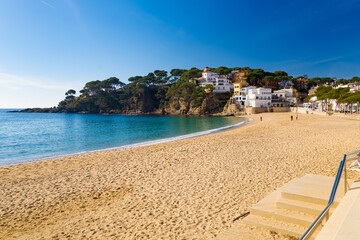 La playa de Llafranc en Cataluña, España, capturada en invierno, con arena dorada, aguas azules...