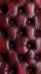 Striking close-up of a regal, tufted burgundy leather surface, capturing the sumptuous feel and depth of the material. The intricate quilting pattern and shiny, velvety finish create a luxurious