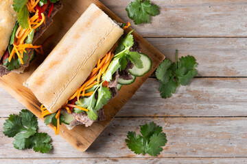 Vietnamese banh mi sandwich on wooden table. Top view. Copy space