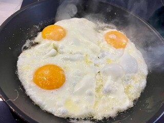 An egg is prepared in a pan for breakfast