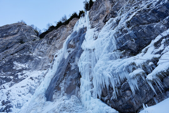 View of a partially frozen waterfall. Beautiful and magical winter holiday scenery for nature lovers. Skakavac waterfall in Sarajevo, Bosnia and Herzegovina.