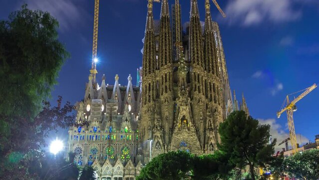 Sagrada Familia: Day to Night Transition Timelapse of the Iconic Roman Catholic Church in Barcelona, Spain. Spires and Cranes Stand Against Reflecting in the Tranquil Waters of the Nearby Lake