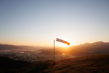 a wind flag on the hill with the sunrise background. It is an image of new hope.