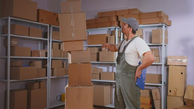 a surprised male worker in a uniform and a bunch of boxes , delivery problems