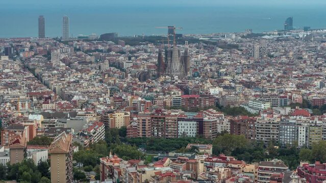 Barcelona Awakening: Night to Day Timelapse Panorama of Spain Vibrant Cityscape. From Bunkers of Carmel, Aerial Top View Frames Sagrada Familia Cathedral, City Lights Gradually Dimming as Dawn Unfolds