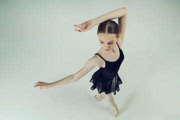 young teen ballerina posing in motion dance elements top view
