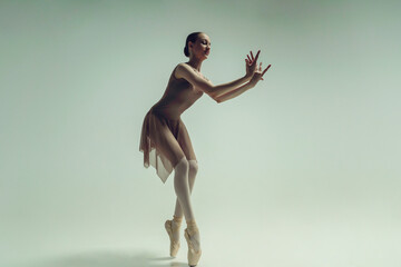 young teenage ballerina poses in a photo studio shows ballet and dance steps - obrazy, fototapety, plakaty