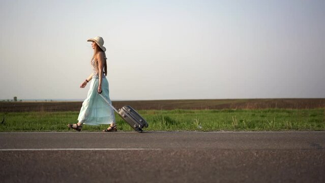 woman walking on the road with luggage