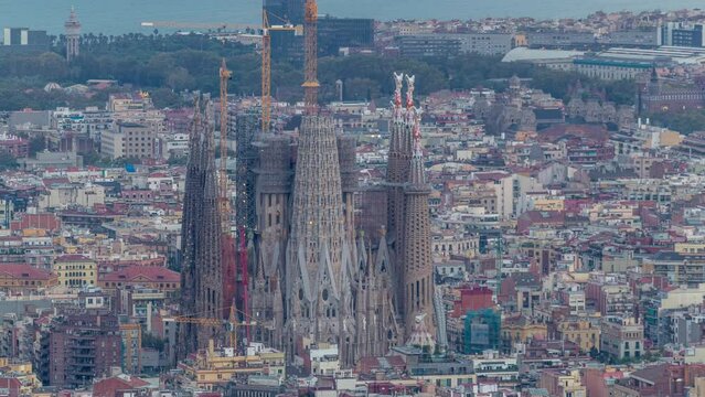 Barcelona's Morning: Night to Day Timelapse Panorama of Spain's Captivating City. Aerial Top View from the Bunkers of Carmel, Sagrada Familia Cathedral, as City Lights Gracefully Dim Before Sunrise