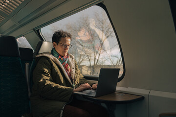 Woman working on laptop while traveling by train