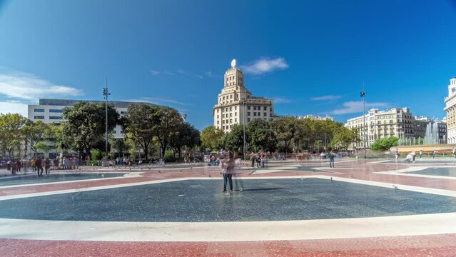 Catalonia in Motion: Timelapse Hyperlapse of the Lively Placa de Catalunya in Central Barcelona. A Dynamic Scene with People, a Central Fountain, and a Stately Building Featuring a Grand Clock
