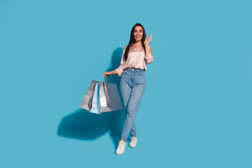 Full size photo of overjoyed woman dressed silk shirt holding shopping bags raising palm up staring...