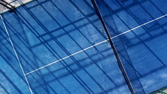 downward drone video footage on a blue paddle tennis court, sports courts