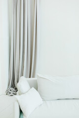 Empty white wall with grey curtain and white couch