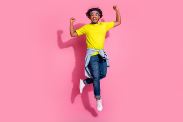 Photo of cheerful crazy man wear stylish yellow clothes celebrate success yes jump up isolated on pink color background