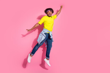 Photo of funky excited positive man wear trendy clothes fly air raised hand empty space isolated on...