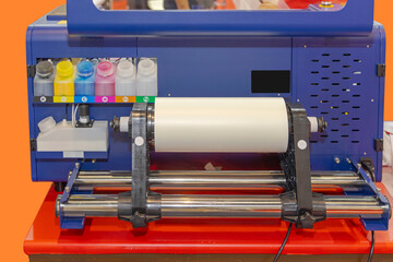 Six Large Ink Bottles and Paper in Roll Material Supply at Printer Back