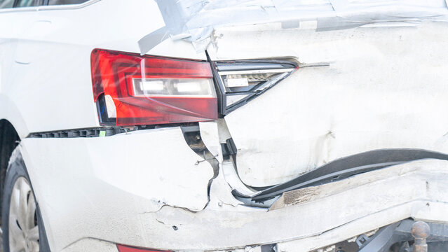 Wrecked car with rear close-up, A white car with a broken rear bumper after a traffic accident.