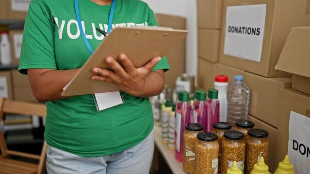 Hispanic woman volunteer inventorying donations in warehouse