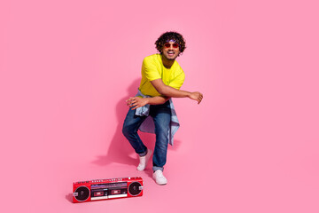 Photo of cool cheerful positive man wear stylish yellow clothes music modern dance isolated on pink color background