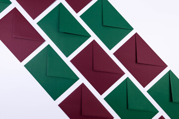 Top view of green and red envelopes on white background. Post flat lay. Copy space.