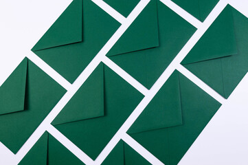 Top view of green envelopes on white background. Post flat lay. Copy space.