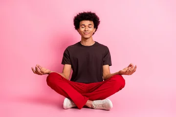 Poster Full body length photo of satisfied smiling guy sitting floor balance concentration lotus practicing yoga isolated on pink color background © deagreez