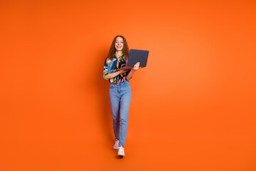 Photo of pretty nice positivegirl wear stylish clothes buy netbook isolated on vivid orange color background