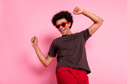 Photo of young cheerful happy energetic rhythm dancing man raised fists up relax clubbing techno music isolated on pink color background