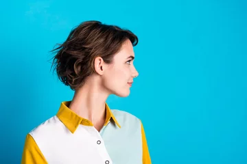 Foto op Canvas Side profile photo of confident bob brown hair lady looking empty space showing her new haircut isolated on blue color background © deagreez