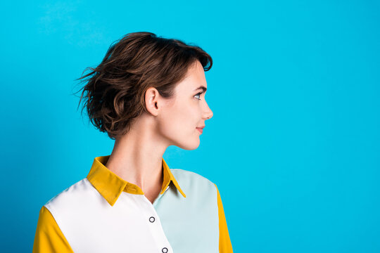 Side profile photo of confident bob brown hair lady looking empty space showing her new haircut isolated on blue color background