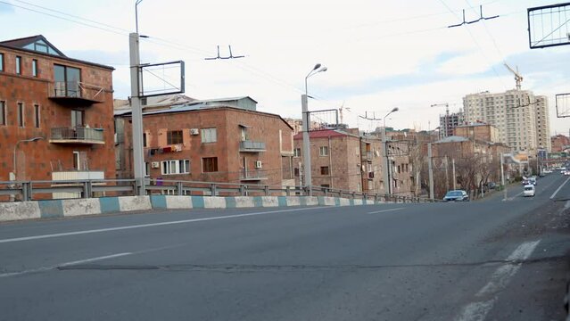 Urban traffic on Lambada bridge overpass in Yerevan, Armenia, against pink tuf stone residential buildings. Cityscape with traffic and architecture, uhd, 4k, 3840, 2160