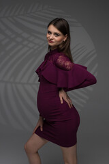 fashion pregnant model posing in studio, pregnant woman stands on a grey background, studio shoot