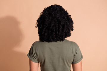 Rear view photo of adorable person with perming coiffure dressed khaki t-shirt demonstrate hairdo...