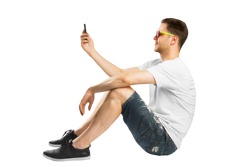 A man in casual attire taking a selfie, with colorful sunglasses, on a white background, concept of social media