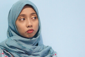 Fototapeta premium Beautiful Asian woman in blue dress and hijab is thinking about something. Isolate white background
