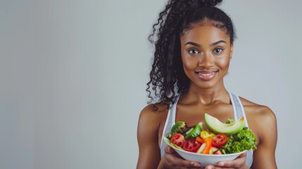 African fitness woman holding a bowl of vegetable salad