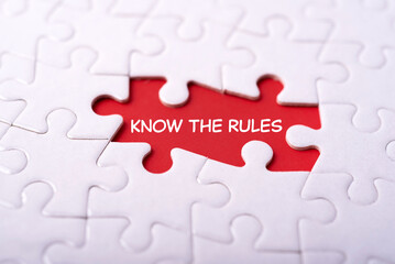 Motivational and inspirational wording. KNOW THE RULES written on background of blurred jigsaw...