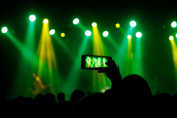 Making photo with smartphone during a concert to share the moment with friends on social networks.