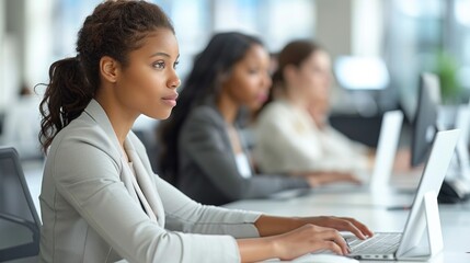 A woman sitting in front of a laptop computer, working or studying