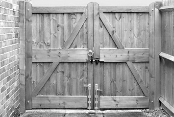Double wooden gates on driveway in black and white