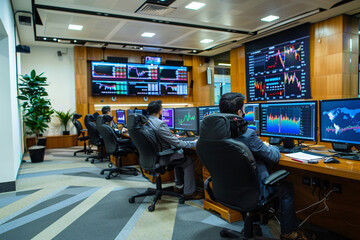 Back view of men sitting in front of computers and monitors