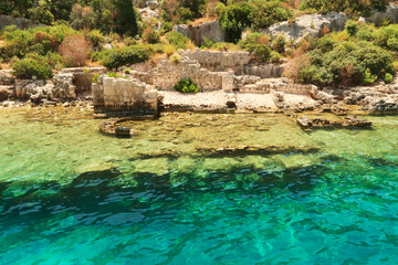 Submerged foundation in the foreground and structures onshore in the background at the ancient sunken city of Kekova, Kekova Island, Demre, Turkey