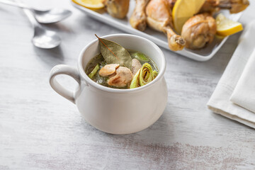 Leek soup and roasted chicken legs on table