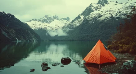 Schilderijen op glas Embark on a retro adventure with a letterboxed image of an orange tent among snowy peaks and calm waters. Enhanced with AI generative techniques for a unique aesthetic. © น้ำฝน สามารถ