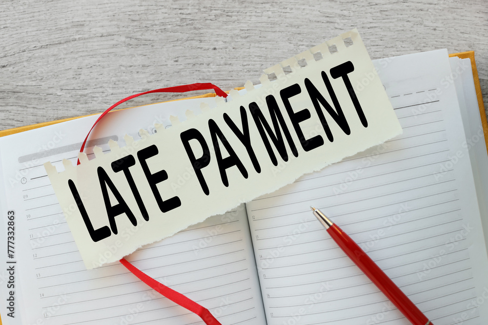 Poster late payment text on a torn page on a notepad
